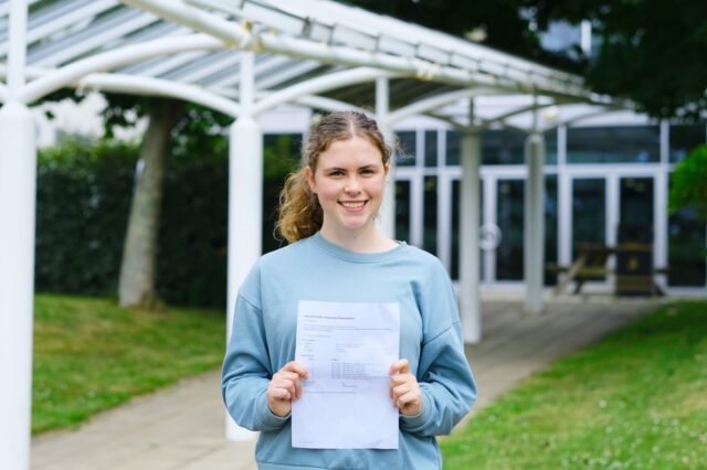 Lauren holds her results up and smiles.