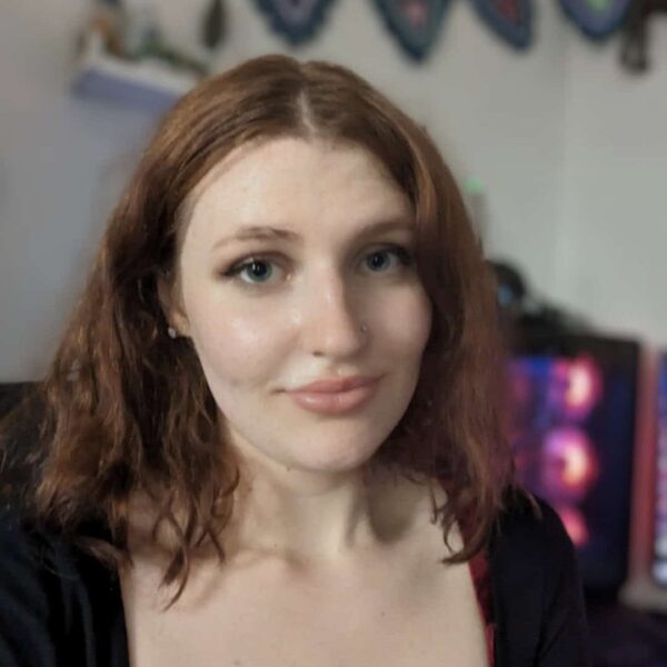 Rey who has long red hair and is wearing a dark top.