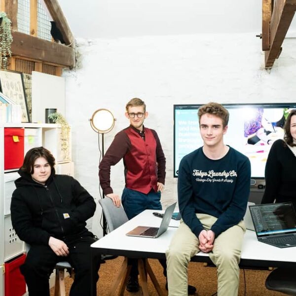 Four workers from HiYield pose around a table.