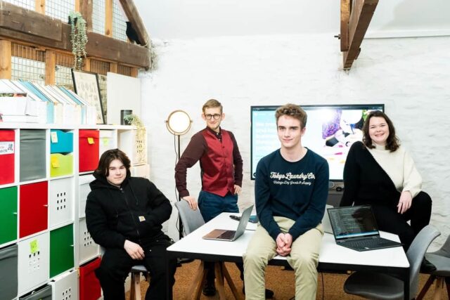 Four workers from HiYield pose around a table.