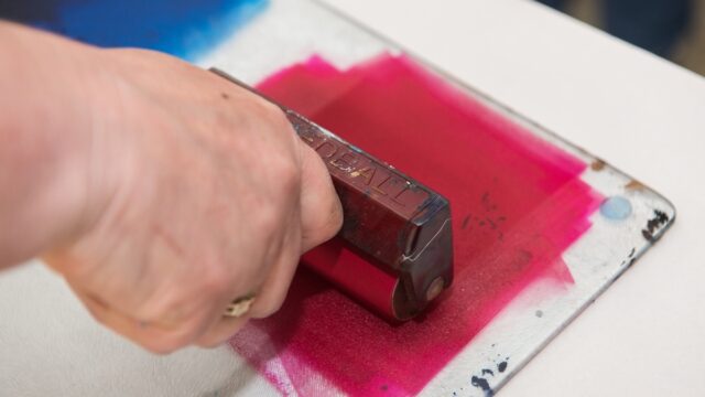 an acrylic paint roller for mono printing and screen printing, rolling paint ready for mono printing.