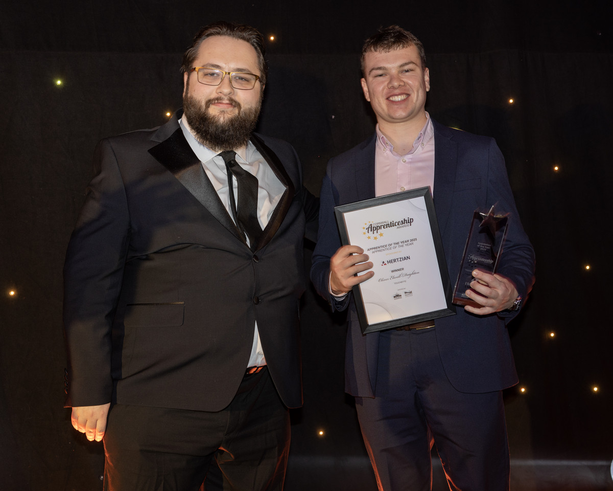 Cornwall's Apprentice of the Year 2025 Oliver Elwell- Deighton receives his award on stage from Andrew Husband. CTO and Co-Founder of Headline Sponsors Hertzian.