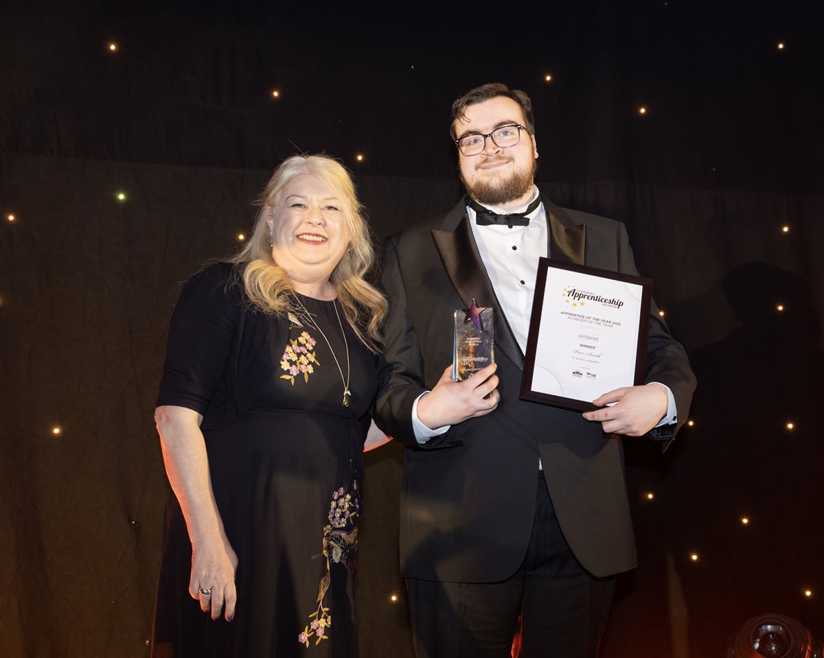 Piers Smith, Winner of the Achiever of the Year category holds his trophy and certificate on stage with Julie-Anne Sunderland from category sponsors Wildanet