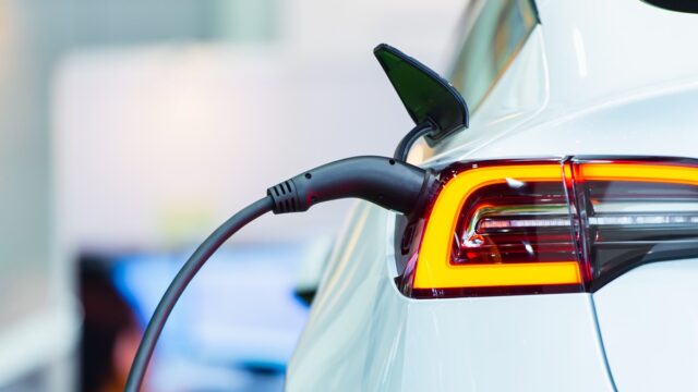 Close up of the Hybrid car electric charger station with power supply plugged into an electric car being charged.
