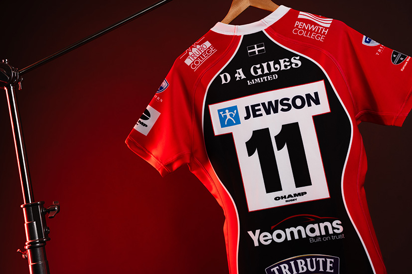 An image of a rugby shirt with sponsorships written on them.