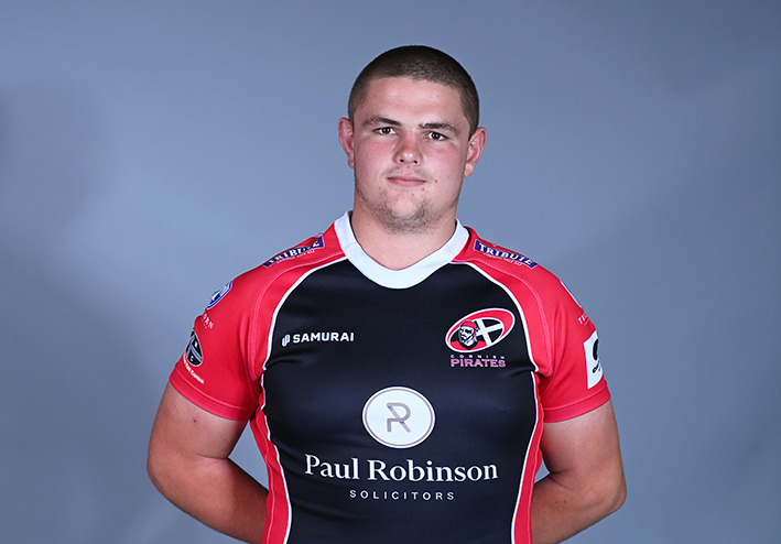 A headshot of a rugby player against a grey background.
