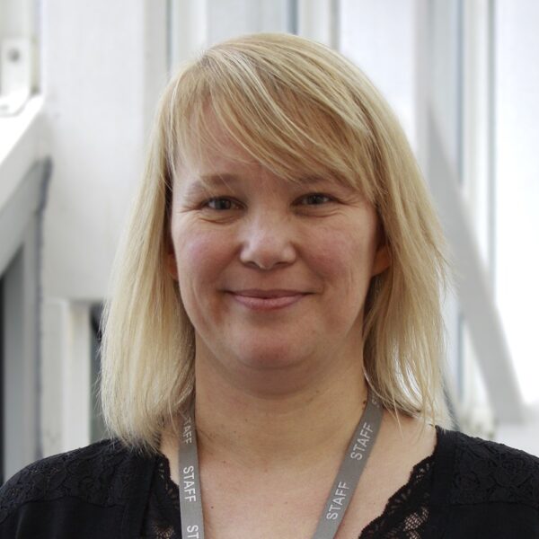 A photo of Mandy wearing black and smiling at the camera.