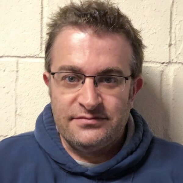 A photo of Robin wearing a blue hoodie and wearing glasses.