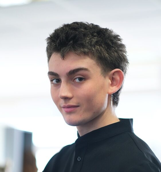 A photo of Spike who is wearing a dark shirt and has a silver earring.