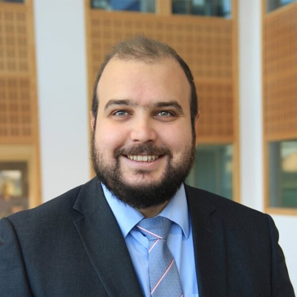 A picture of Tom Moran wearing a suit and smiling at the camera.