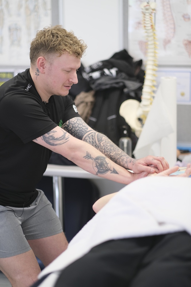 Ross is performing sports therapy on a patient.