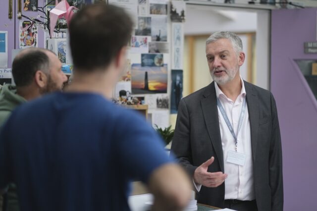Principal Carl Riding chatting to two members of staff at the College.