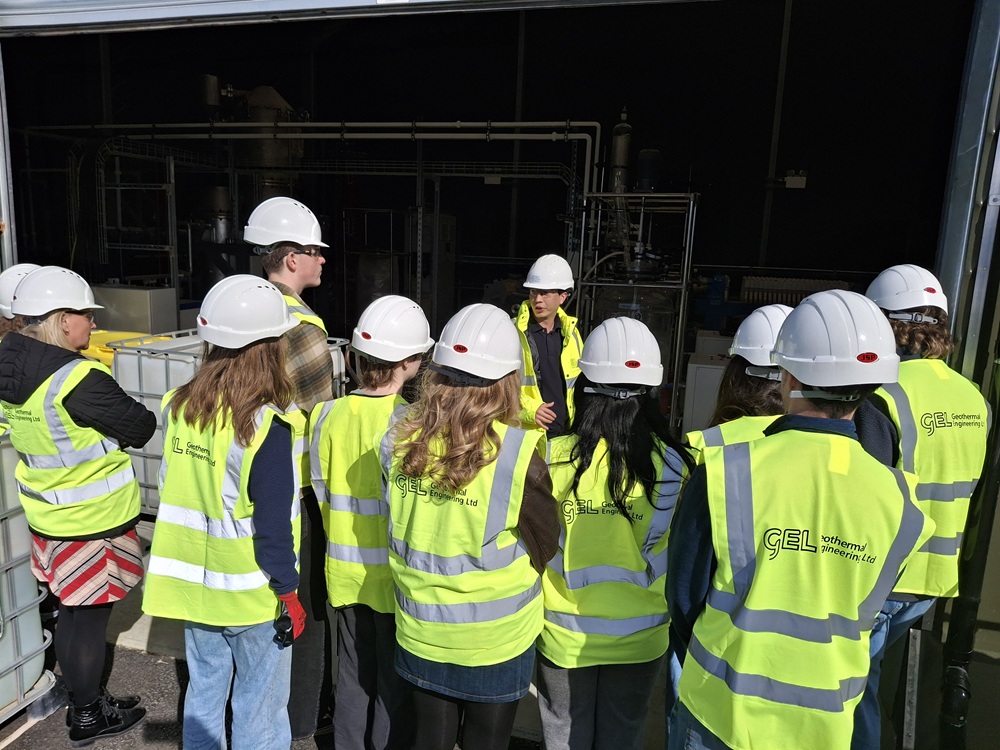 A group of people wearing high vis jackets that say Geothermal Engineering Ltd on the backs.