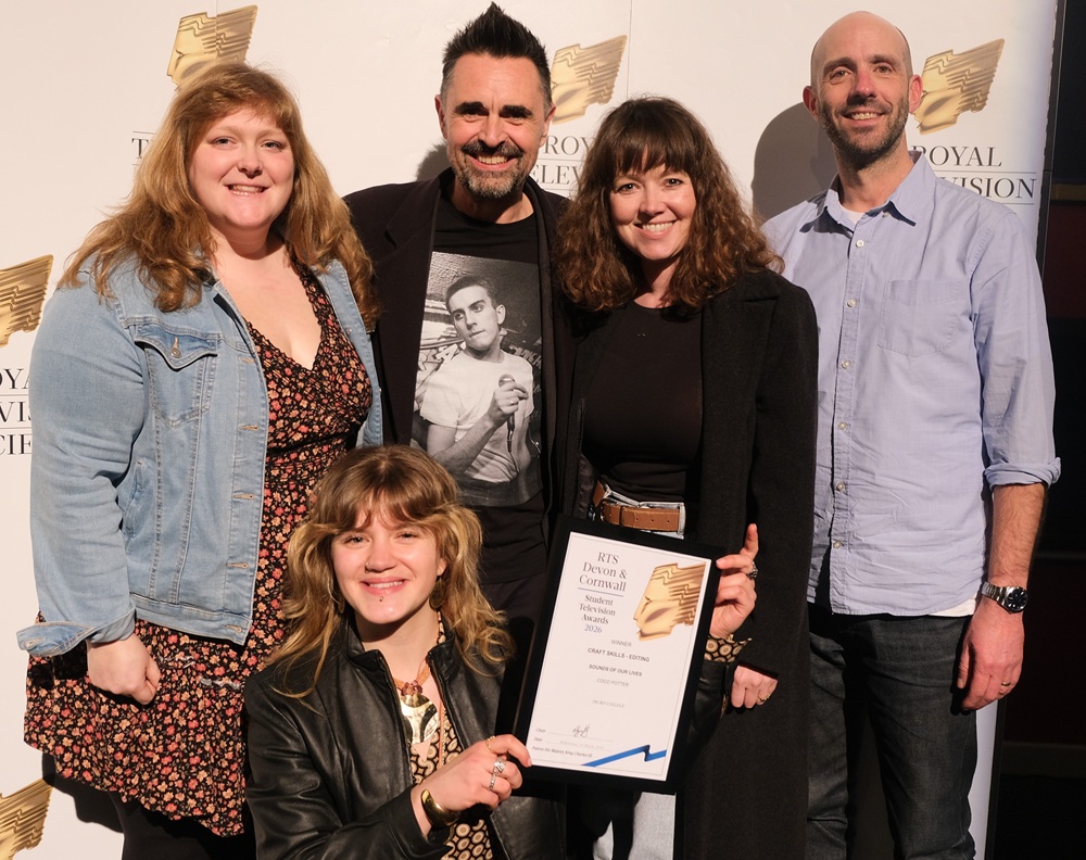 Lecturers and senior management stand with a student who has received an award.