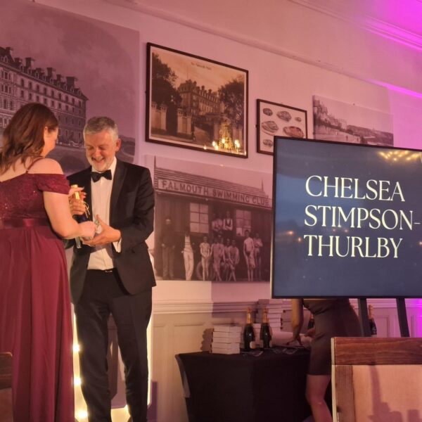 Principal Carl Riding presents an award to a young woman at the 30 under 30 awards.