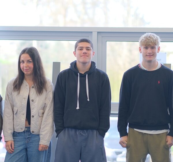 Five students lined up smiling at the camera.