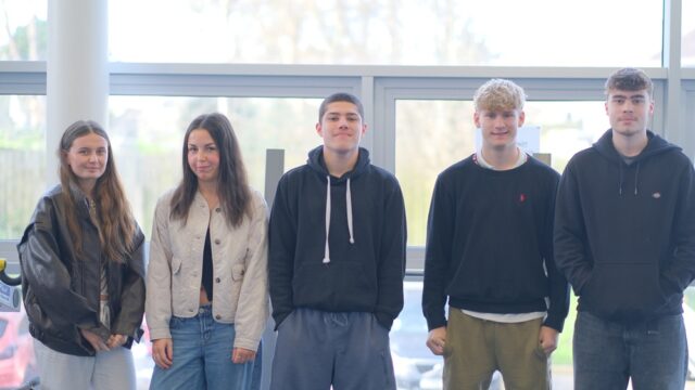 Five students lined up smiling at the camera.