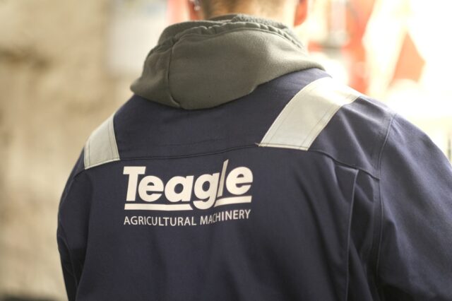 The back of a worker's jacket that says Teagle Agricultural Machinery.