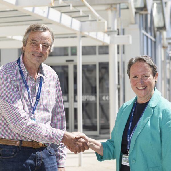 Robert Townsend and Kay Penny shaking hands outside the Allen building at Truro College.