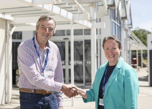 Robert Townsend and Kay Penny shaking hands outside the Allen building at Truro College.