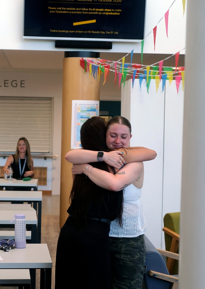 Two students hug each other underneath bunting at the HE Results Day 2026.