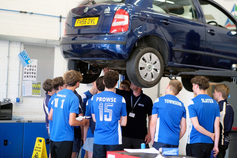 Students look underneath a vehicle.