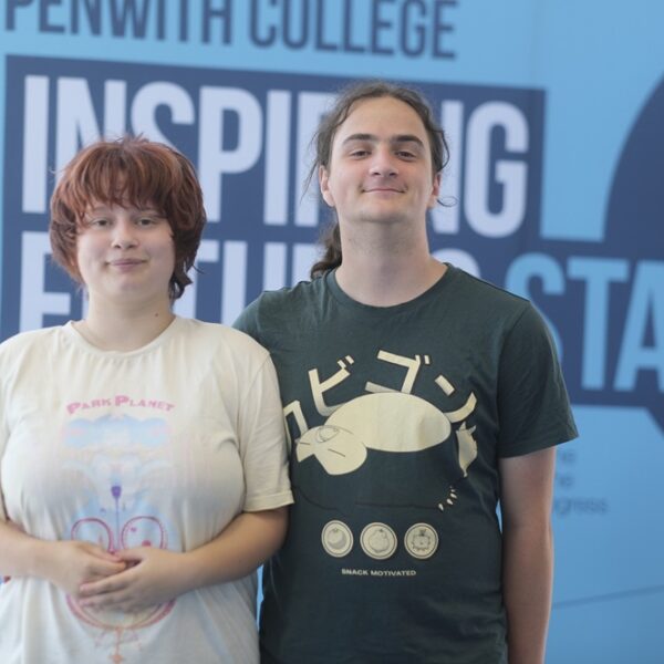 Charlie and Chloe stood side by side with a Penwith College banner and star balloons behind them.