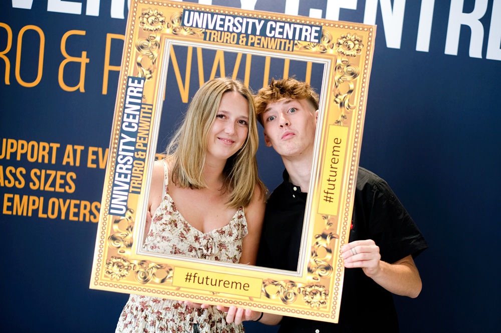 Kenza and a friend are holding up a picture frame around them that says 'University Centre Truro & Penwith' and '#futureme'.