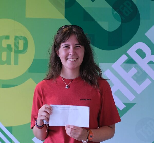 Mirryn against a Truro and Penwith green backdrop, holding up her results.