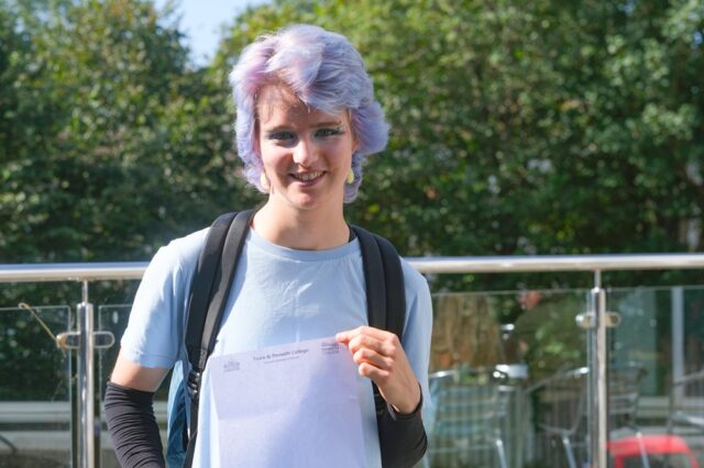 Ryn is holding up their results stood outside at Penwith College.