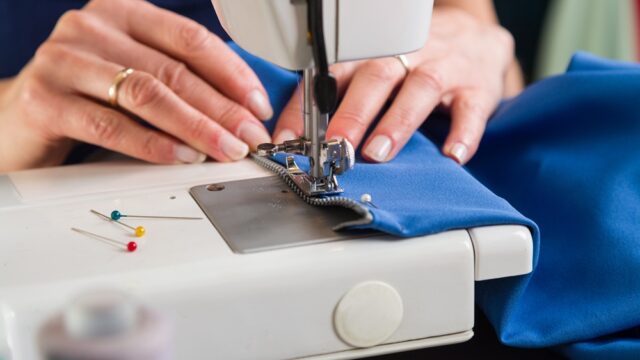 Sewing workshop. Sewing zipper on sewing machine.