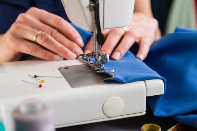 Sewing workshop. Sewing zipper on sewing machine.