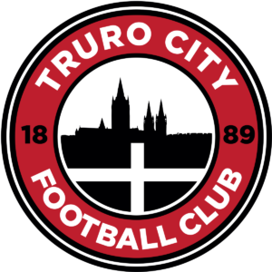 A red circle with Truro City Football Club 1889 written around it. Truro cathedral silhouette in the middle with the cornish flag.