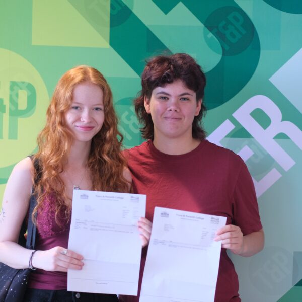 Keira (left) stands with Frances (right), both smiling as they hold their results letters.