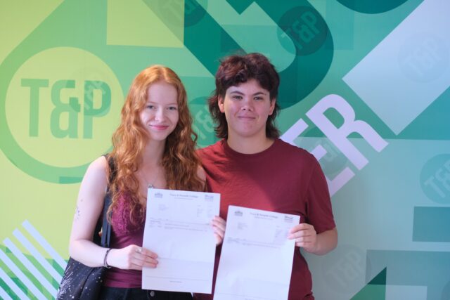 Keira (left) stands with Frances (right), both smiling as they hold their results letters.