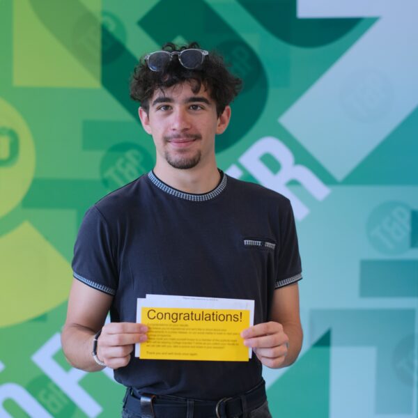 Casey smiles as he holds his results letter
