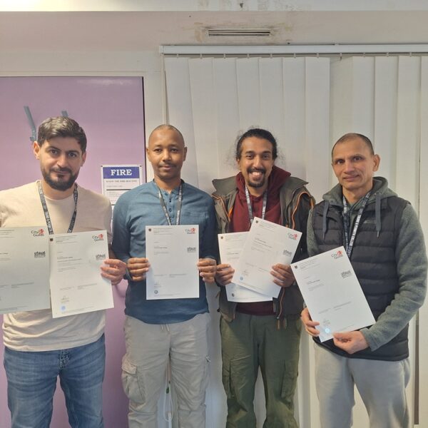 Four men hold up certificates at Truro College.