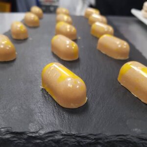 Yellow sweets served on a dark grey slate.