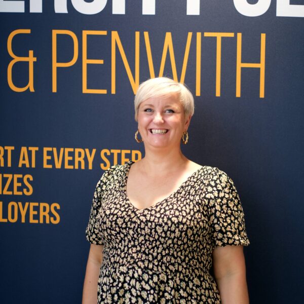 Tasha stood smiling in front on University Centre banner