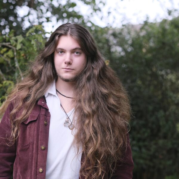 Tom stood smiling in front of trees