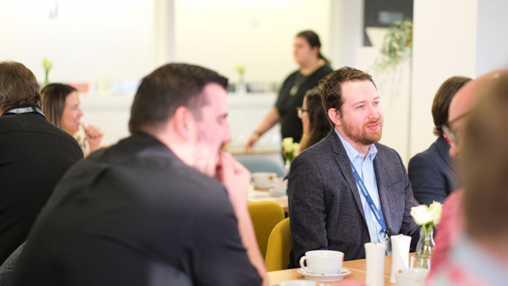 Christopher Weavill, Co-founder and CEO of Hertzian, pictured seated, smiling.