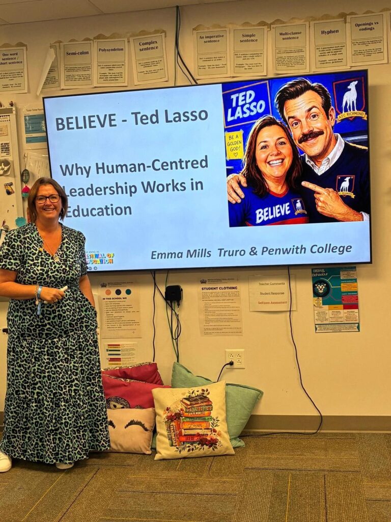 A member of staff stood in front of a presentation that says Believe - Ted Lasso. Why human-centred leadership works in education.