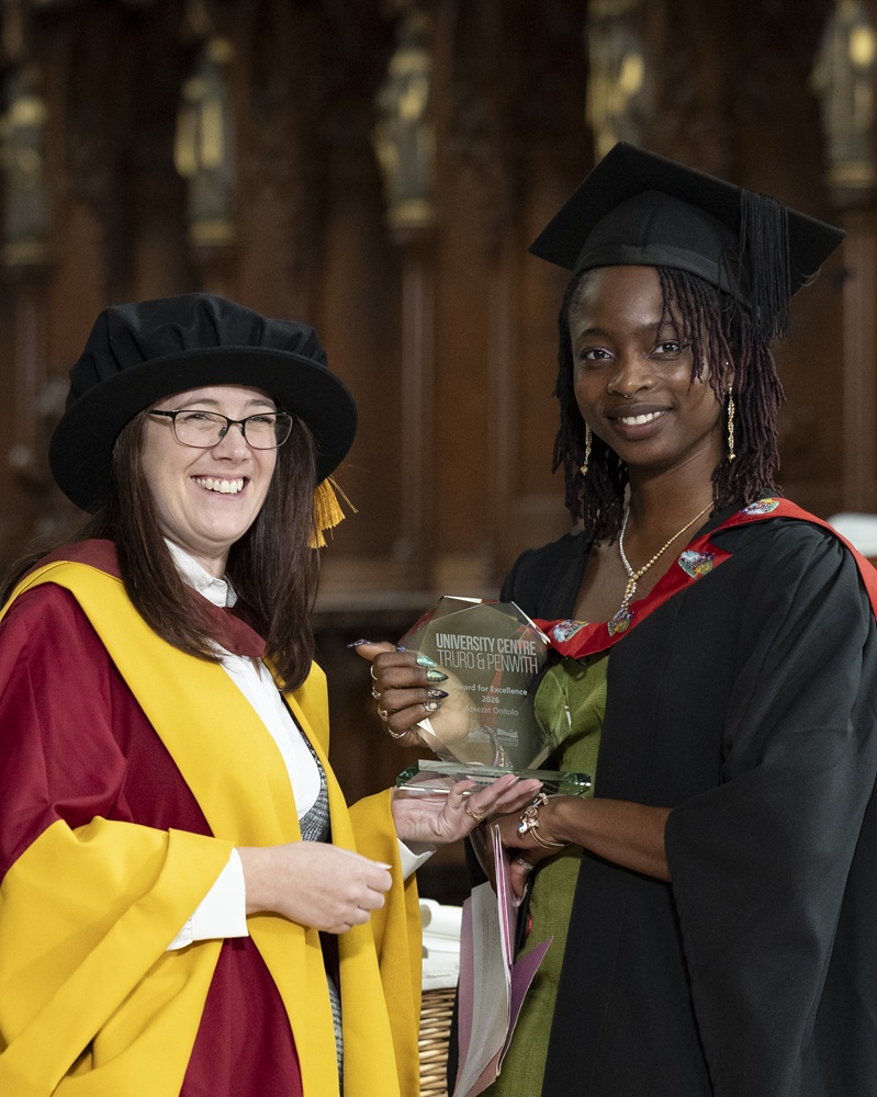 The dean of the university centre handing an award to the student orator.